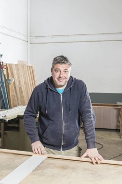 Çalışan adam kavramı. Doğrama atölyesinde çalışan erkek marangoz.