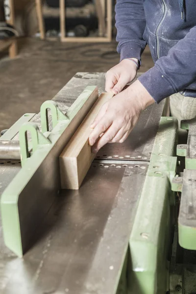 Çalışan adam kavramı. Doğrama atölyesinde çalışan erkek marangoz.