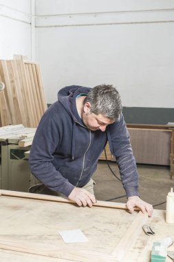 Çalışan adam kavramı. Doğrama atölyesinde çalışan erkek marangoz.