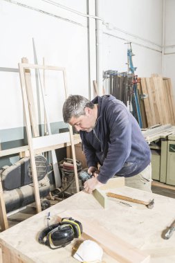 Çalışan adam kavramı. Doğrama atölyesinde çalışan erkek marangoz.