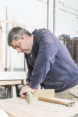 Çalışan adam kavramı. Doğrama atölyesinde çalışan erkek marangoz.