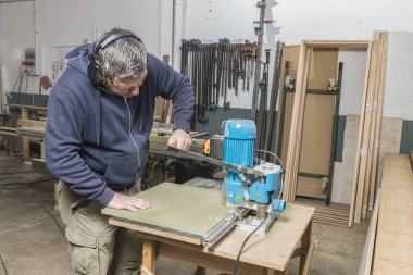 Doğrama atölyesinde çalışan erkek marangoz.