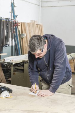 Doğrama atölyesinde çalışan erkek marangoz.