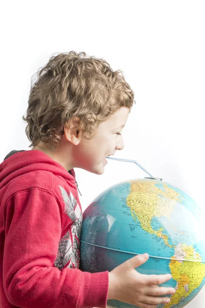 Child holding a globe in his arms and drinking from it with a st — Stock Photo, Image