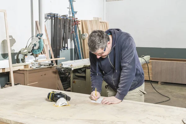 Doğrama atölyesinde çalışan erkek marangoz.