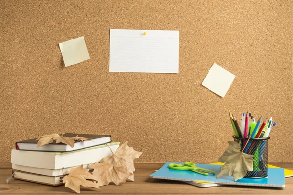 コルク板を背景にした木製ボードの書籍、ノート、学用品. — ストック写真
