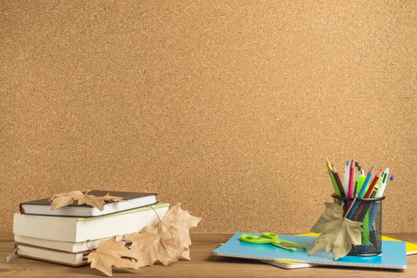 コルク板を背景にした木製ボードの書籍、ノート、学用品. — ストック写真