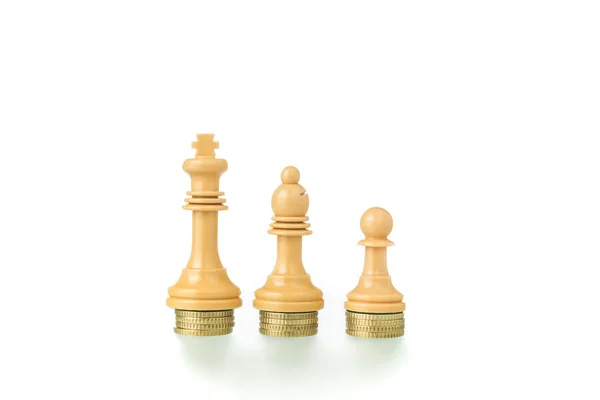 Foto conceptual con piezas de ajedrez y monedas que muestran el concepto —  Fotos de Stock