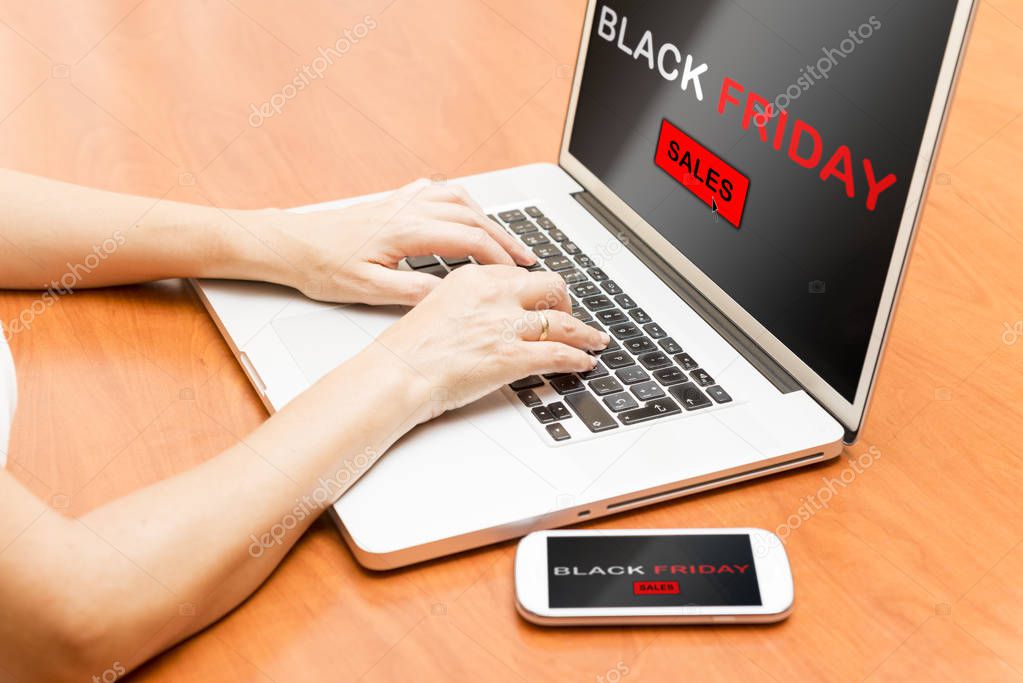 Detail of a woman's hands typing on a laptop.