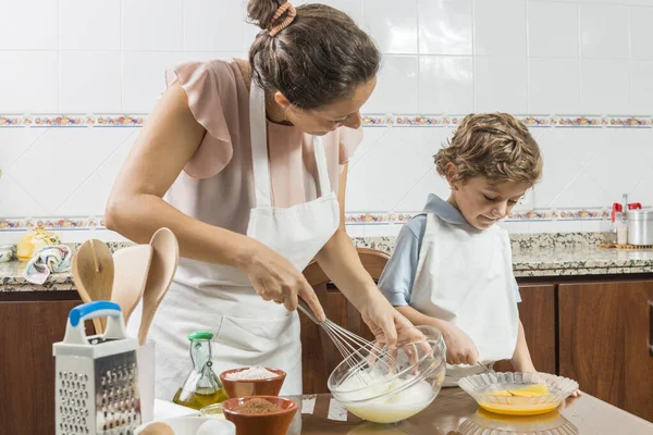 Een vrouw en een kind samen koken. — Stockfoto