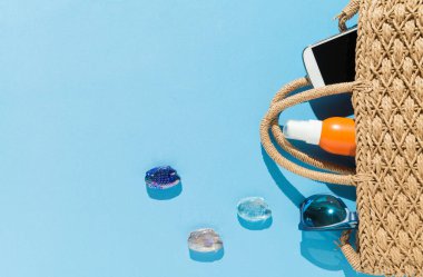 Mavi arkaplandaki plaj nesnelerinin üst görüntüsü. Yaz ve tatil konsepti.