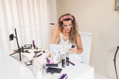 Genç bayan vlogger video bloğu için bir makyaj videosu kaydediyor. Sosyal medya kavramında pazarlama üzerinde etkili.