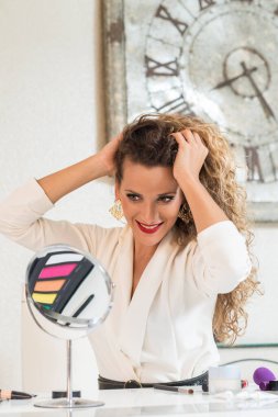 Kafkasyalı genç kadın kendine bakıyor ve aynanın önünde poz veriyor..