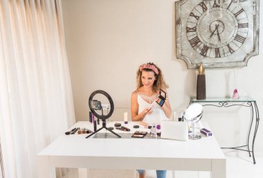 Genç bayan vlogger video bloğu için bir makyaj videosu kaydediyor. Sosyal medya kavramında pazarlama üzerinde etkili.