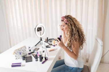 Genç bayan vlogger video bloğu için bir makyaj videosu kaydediyor. Sosyal medya kavramında pazarlama üzerinde etkili.