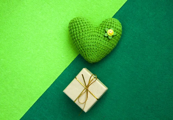 Corazón de punto verde y caja de regalo sobre un fondo verde, un símbolo de amor para felicitar a la fiesta — Foto de Stock