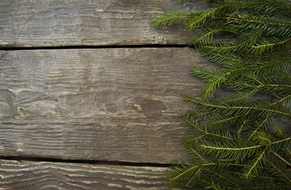Quadro de fundo de Natal brilhante com um espaço de cópia com ramos de abeto com uma mesa de madeira — Fotografia de Stock