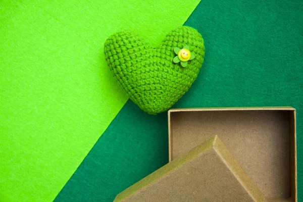 Corazón de punto verde y caja de regalo sobre un fondo verde, un símbolo de amor para felicitar a la fiesta — Foto de Stock