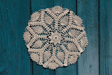 Mavi ahşap arka planda güzel bir dantel örgü.