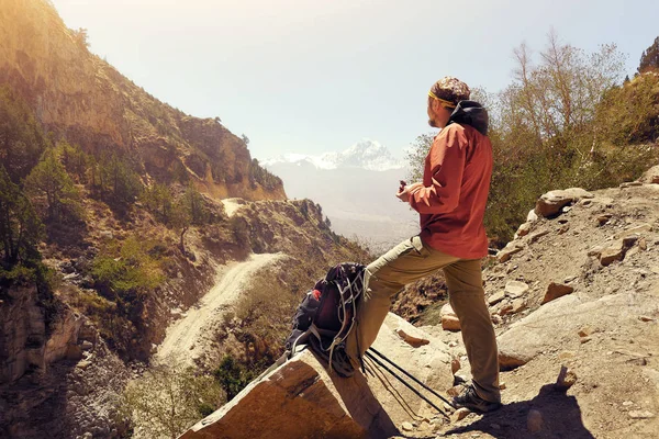 ネパールの上のマスタングで山道のハイキング中に食べるハイカー男健康な屋外生活 — ストック写真