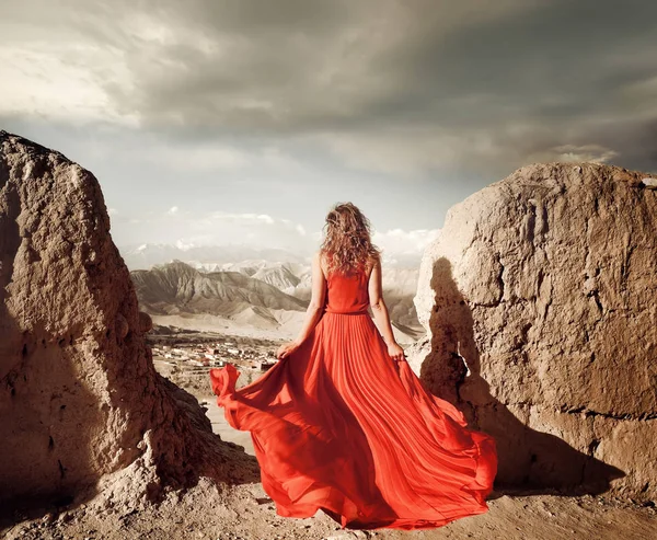 Woman Long Red Dress Edge Cliff Mountains Looking Sunny Valley — Stock Photo, Image