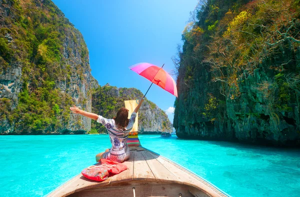 Joyful woman with umbrella travels in summer clothes on a boat a — Stock Photo, Image