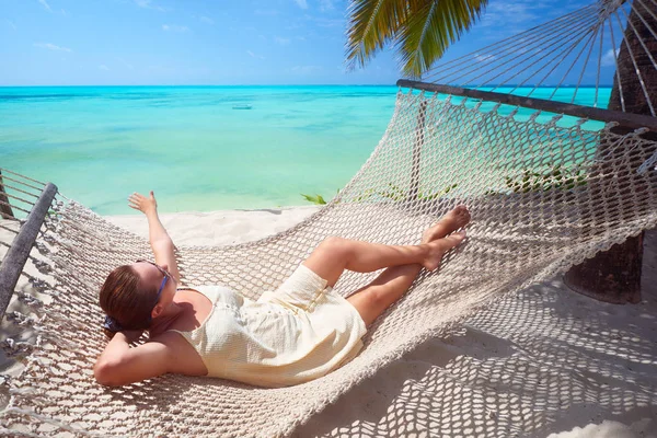 Vrouw is ontspannen in hangmat op het strand tussen de Palm in de buurt van th — Stockfoto