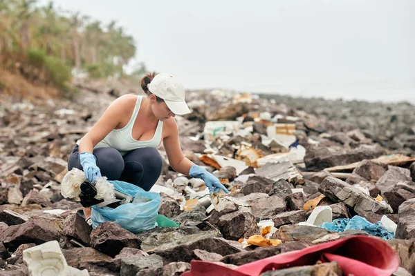 Женщина помогает очистить береговую линию от пластикового мусора — стоковое фото