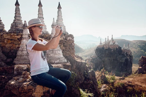 Young woman traveller photographs landscape and stupas in the te — Stock Photo, Image