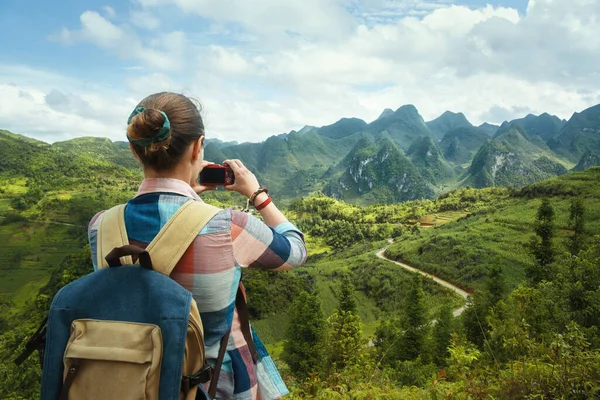 Woman Traveler with backpack, photographs beautiful view of the karsts mountains in the North of Vietnam. — Stock Photo, Image