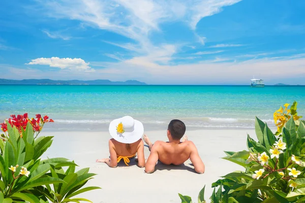 Glada par vilar på tropisk strand på sommaren solig dag på bakgrund av vacker blå himmel och turkost hav. — Stockfoto