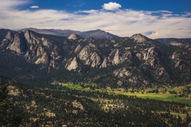 Doğal Vadisi ve karla kaplı tepeler bulutlar Estes Park, Colorado'da bir mavi gökyüzü altında Rocky Mountain National Park yakınındaki. Umudu dağın zirvesine üzerinden havadan görünümü.