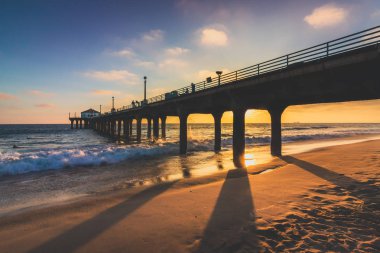 Renkli gökyüzü ve gün batımında sahilde, Manhattan Beach, Kaliforniya döküm uzun gölgeler ile Manhattan Beach iskelesinden üzerinde bulutlar