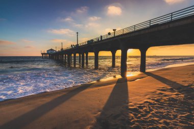 Renkli gökyüzü ve gün batımında sahilde, Manhattan Beach, Kaliforniya döküm uzun gölgeler ile Manhattan Beach iskelesinden üzerinde bulutlar