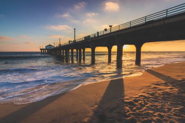 Renkli gökyüzü ve gün batımında sahilde, Manhattan Beach, Kaliforniya döküm uzun gölgeler ile Manhattan Beach iskelesinden üzerinde bulutlar