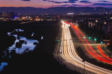 Lincoln Bulvarı, Ballona sulak alanlar ve Santa Monica Dağları arka planda gökyüzünde güneş battıktan sonra Playa Vista, California yansıtan su yoğun trafik ışık yollar