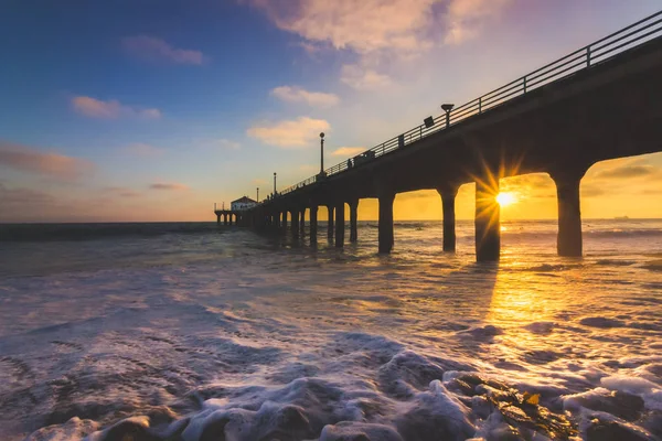 Renkli gökyüzü ve bulutlar üzerinde Manhattan Beach iskelesinden yumuşak dalgalar sahile, Manhattan Beach, Kaliforniya yıkama ile gün batımında