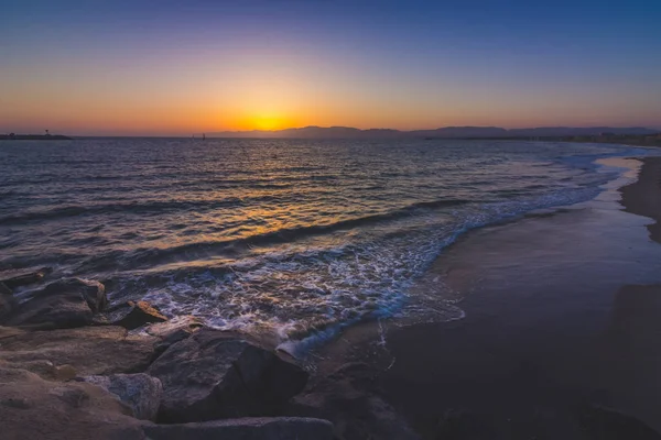 Uzun pozlama atış bir dalgalar deniz feneri plaj güneş üzerine yıkama ayarlar Santa Monica dağlar, Marina Del Rey, California