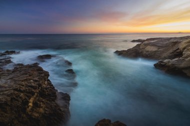 Yumuşak dalgalar çökmesini gün batarken, Leo Carrillo devlet Beach, Malibu, Kaliforniya kaya oluşumları Sequit noktada içine uzun pozlama görünümünü çarpıcı