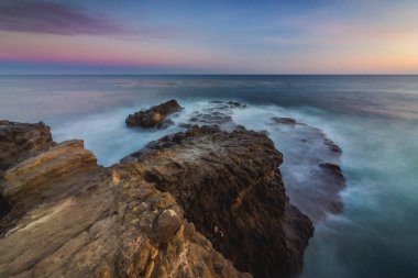Yumuşak dalgalar çökmesini gün batarken, Leo Carrillo devlet Beach, Malibu, Kaliforniya kaya oluşumları Sequit noktada içine uzun pozlama görünümünü çarpıcı