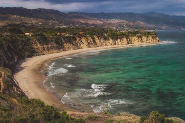 Güzel Turkuaz Pasifik Okyanusu ve çarpıcı uçurum Dume Cove ile Santa Monica dağ aralığı içinde geçmiş, nokta Dume, Malibu, Kaliforniya çevreleyen yükseltilmiş görünümünü