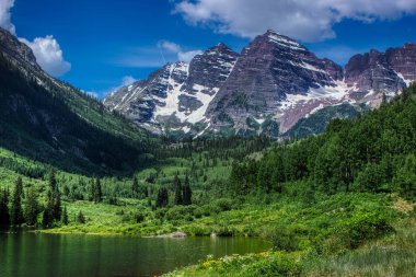 Güneşli bir günde görkemli Maroon Bells tepeleri ve Maroon Gölü ve yazın Aspen, Colorado yakınlarında mavi gökyüzü