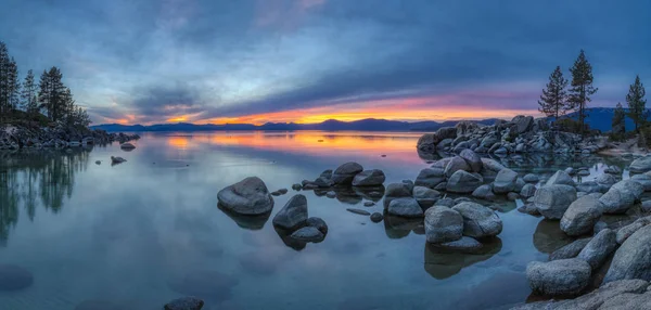 Günbatımında sakin su, güzel kaya oluşumları ve arka plan, Lake Tahoe, Carson City, Nevada dağlarında renkli gökyüzü kum Harbor