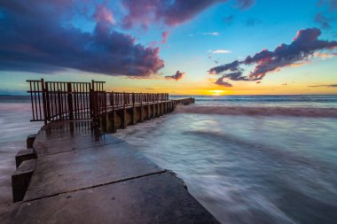 Uzun pozlama fotoğraf renkli bulutlar gökyüzünde, ayak parmakları Beach, Playa Del Rey, California ile gün batımında Mcgurk Beach iskelesi çökmesini dalgaları