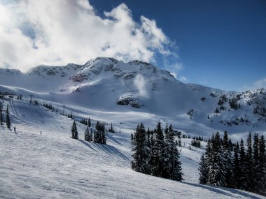 Whistler dağ tepe görünümünü güneşli bir günde dağın haddeleme bulutlar Whistler Blackcomb Kayak Merkezi, Whistler, British Columbia, Kanada ile çarpıcı.