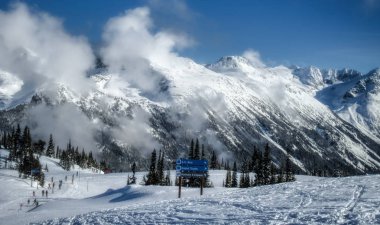Bulutlar kar, Whistler Blackcomb Kayak Merkezi, Whistler, British Columbia, Kanada taze bir döküm sonra güneşli bir günde Blackcomb dağ kapsayan yamalari