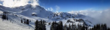Whistler dağ tepe görünümünü güneşli bir günde dağın haddeleme bulutlar Whistler Blackcomb Kayak Merkezi, Whistler, British Columbia, Kanada ile çarpıcı.