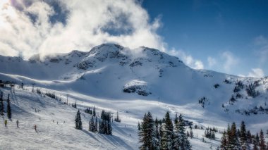 Whistler dağ tepe görünümünü güneşli bir günde dağın haddeleme bulutlar Whistler Blackcomb Kayak Merkezi, Whistler, British Columbia, Kanada ile çarpıcı.