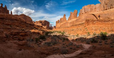 Manzaralı manzara, Park Avenue Trail, Arches National Park, Moab, Utah boyunca görülen tek taş kaya yapılarıyla çevrili bir kanyona bakıyor.