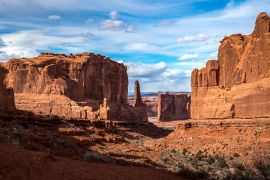 Scenic view of monolithic sandstone rock structures seen along the Park Avenue Trail with Tower of Babel in the distance, Arches National Park, Moab, Utah clipart